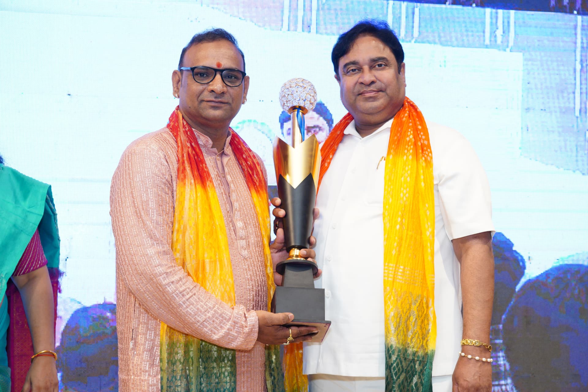 Aacharya Vishnu Sharma holding a golden trophy
